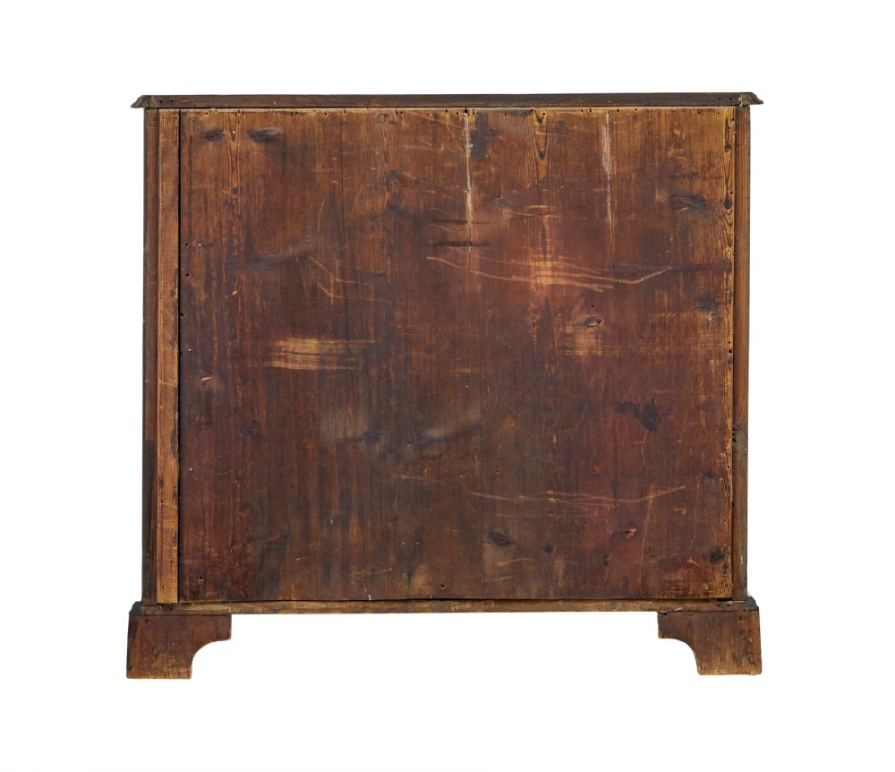 An early 19th-century walnut chest of drawers featuring four graduating drawers with brass handles, carved fretwork corners, and bracket feet. View VII