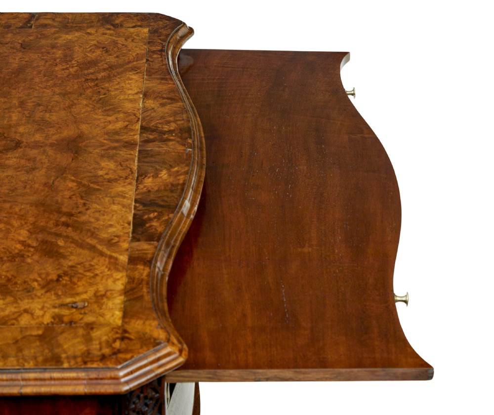 An early 19th-century walnut chest of drawers featuring four graduating drawers with brass handles, carved fretwork corners, and bracket feet. View X
