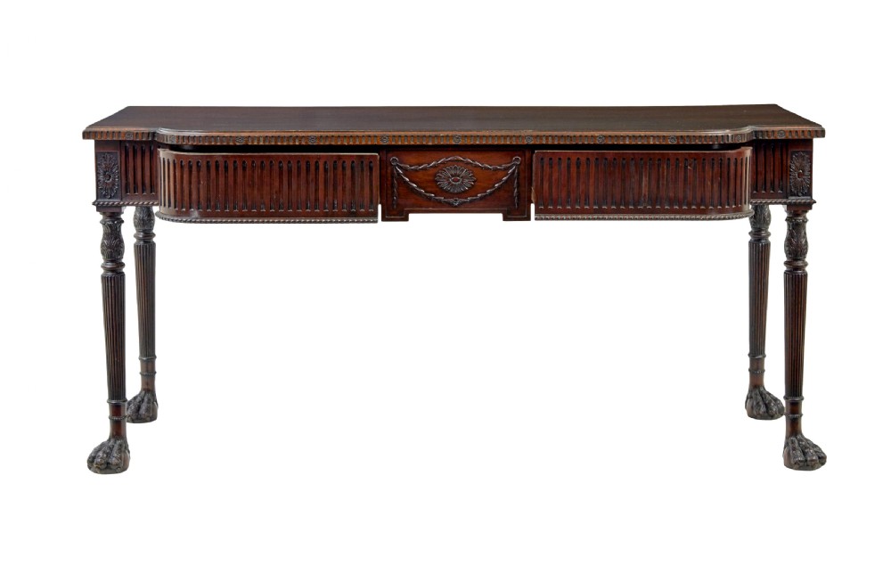 A nineteenth-century dark mahogany Irish serving table featuring a reeded frieze, central drawer with carved swag motif, and fluted legs with carved feet. View III
