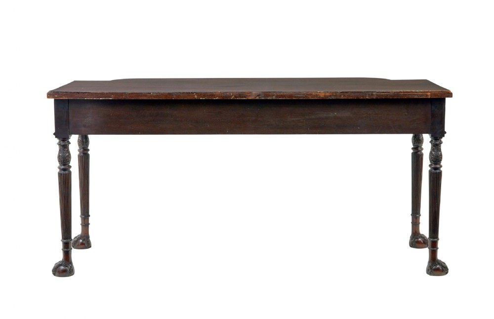 A nineteenth-century dark mahogany Irish serving table featuring a reeded frieze, central drawer with carved swag motif, and fluted legs with carved feet. View V