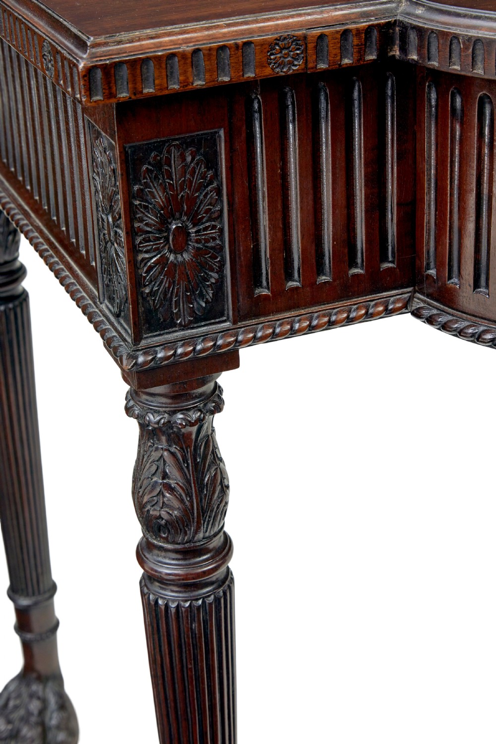 A nineteenth-century dark mahogany Irish serving table featuring a reeded frieze, central drawer with carved swag motif, and fluted legs with carved feet. View VII