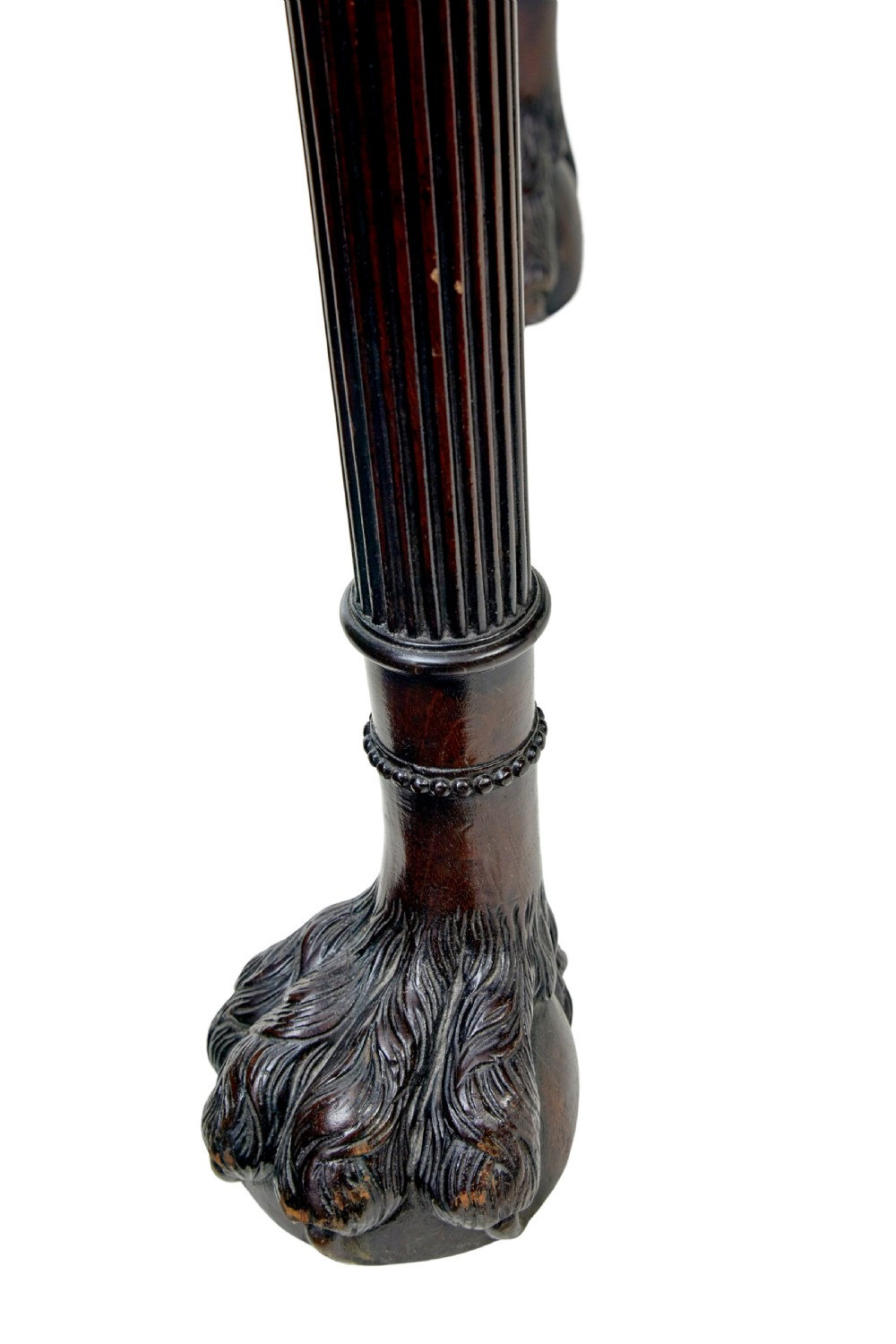 A nineteenth-century dark mahogany Irish serving table featuring a reeded frieze, central drawer with carved swag motif, and fluted legs with carved feet. View IX