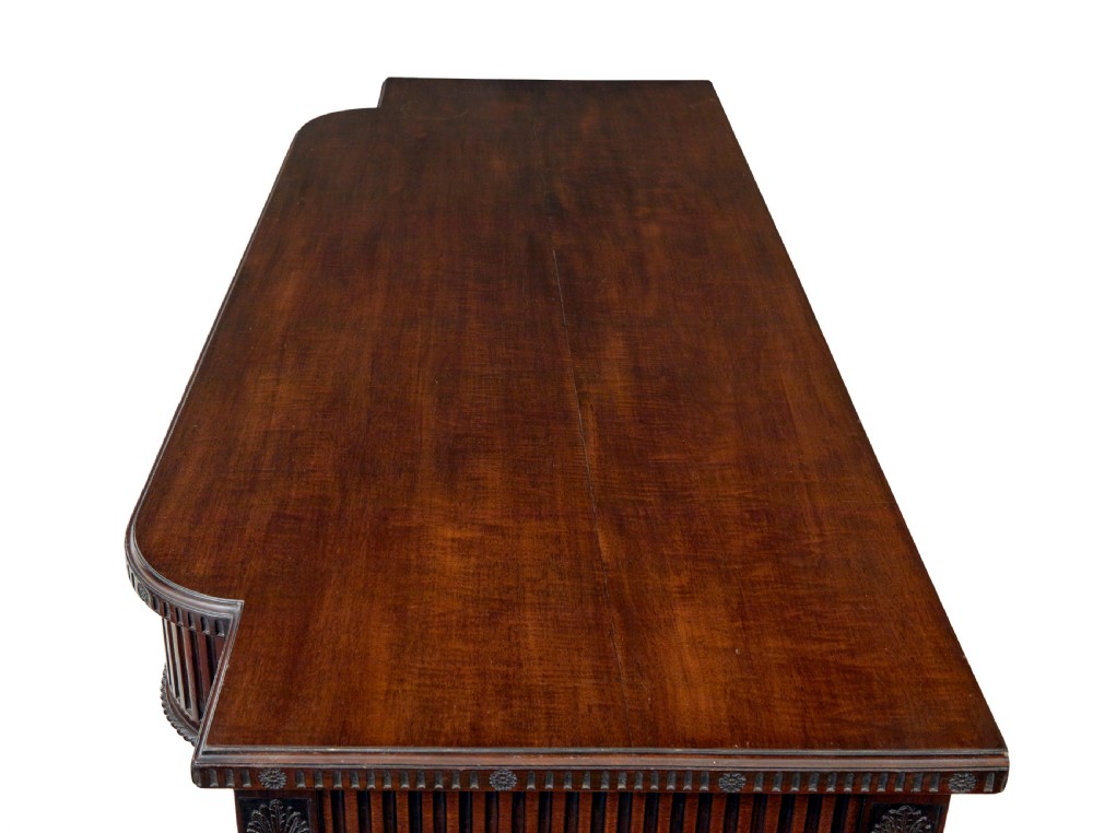 A nineteenth-century dark mahogany Irish serving table featuring a reeded frieze, central drawer with carved swag motif, and fluted legs with carved feet. View XI