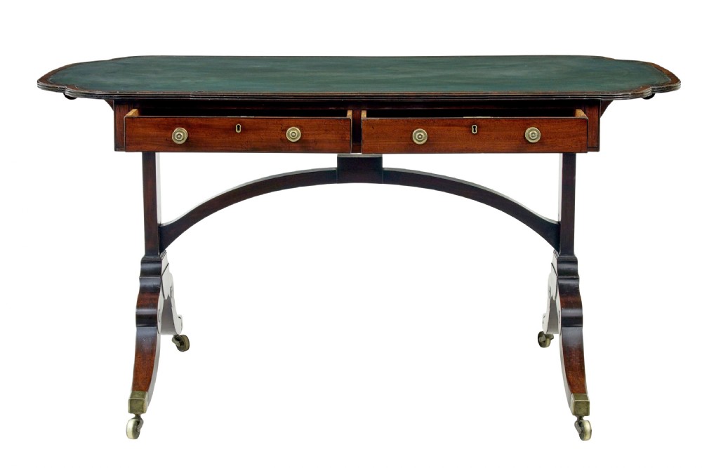 An early Victorian mahogany writing table featuring a green leather top, two drawers, an arched stretcher, and legs on brass castors. View II