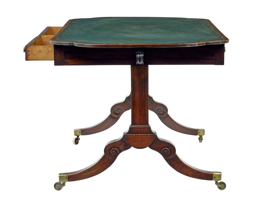 An early Victorian mahogany writing table featuring a green leather top, two drawers, an arched stretcher, and legs on brass castors. View III