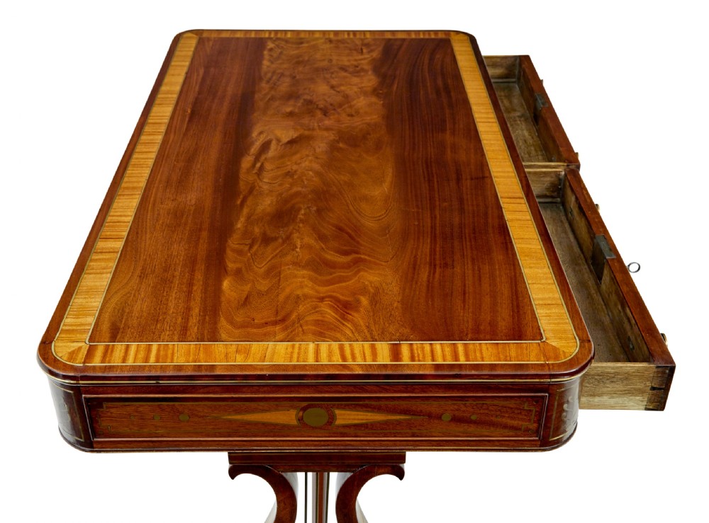 A 19th-century Regency writing desk featuring brass inlay, two frieze drawers, lyre-shaped end supports, and brass paw feet on castors. View III