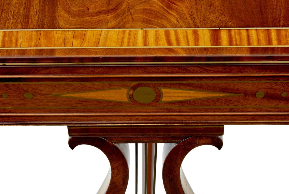 A 19th-century Regency writing desk featuring brass inlay, two frieze drawers, lyre-shaped end supports, and brass paw feet on castors. View IV