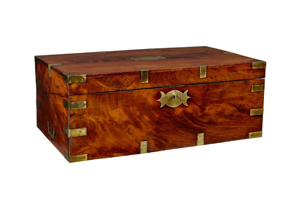 A mid-19th century mahogany campaign writing slope with protective brass-bound corners, a brass keyhole escutcheon, and flush side handles.