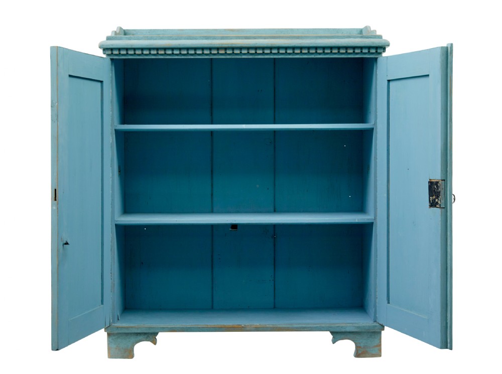 A 19th-century Scandinavian pine double-door cupboard with a distressed light blue painted finish, dentil moulding along the top, and cut-out bracket feet. View V