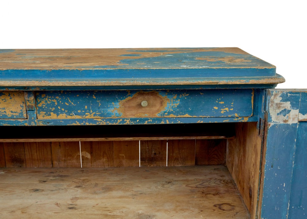 A mid-19th-century Scandinavian pine cupboard featuring distressed blue paint, two panelled doors with painted floral motifs, and short block feet. View IX