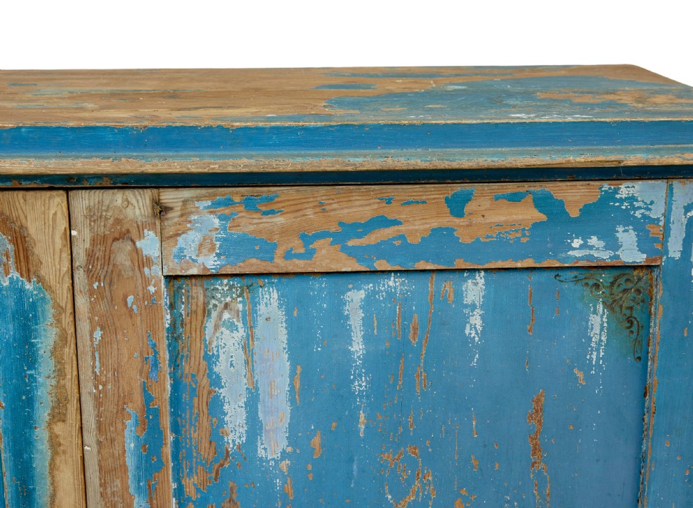 A mid-19th-century Scandinavian pine cupboard featuring distressed blue paint, two panelled doors with painted floral motifs, and short block feet. View X