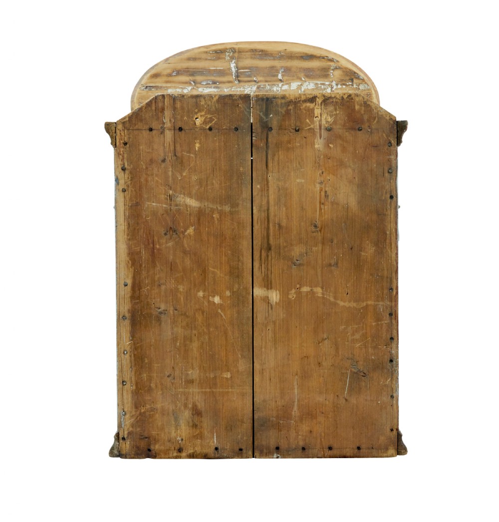 A 19th-century Finnish painted pine wall cupboard featuring weathered light blue paint, an arched pediment crest, and a door panel carved with a diamond pattern. View VI