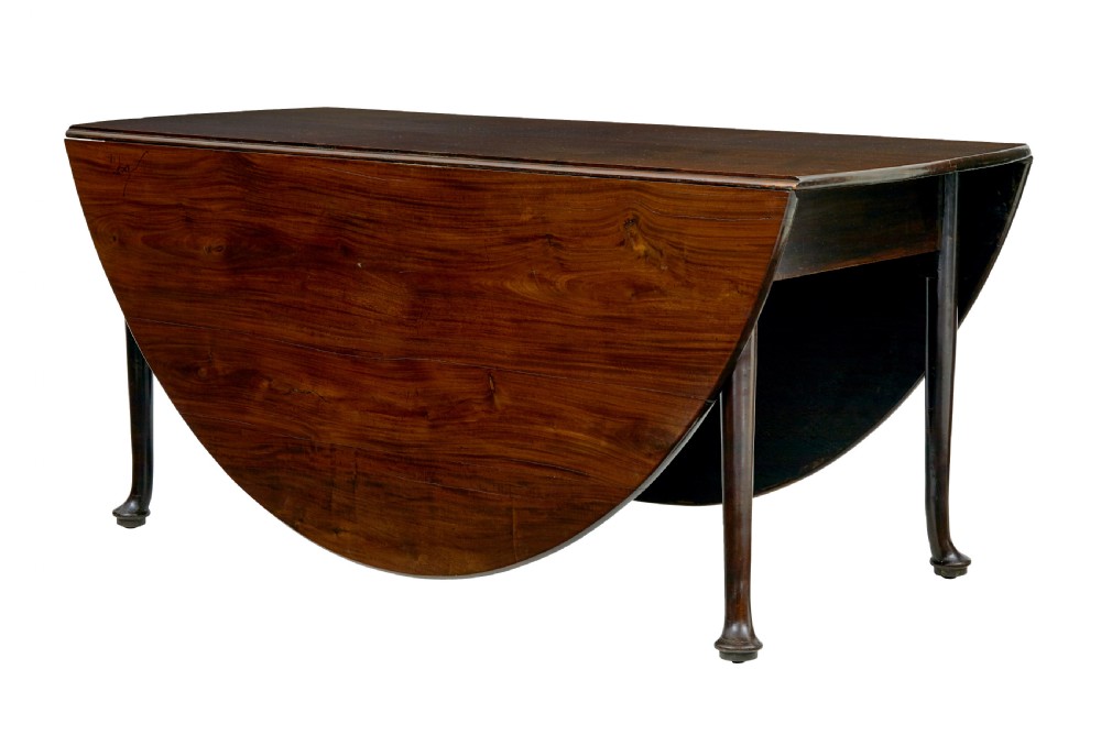 An early nineteenth-century Georgian dark mahogany drop-leaf dining table shown with both flaps lowered and tapered legs visible.