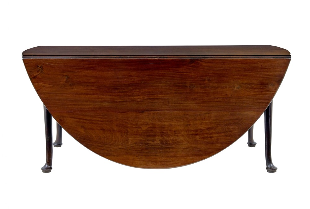 An early nineteenth-century Georgian dark mahogany drop-leaf dining table shown with both flaps lowered and tapered legs visible. View II