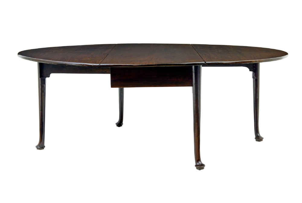 An early nineteenth-century Georgian dark mahogany drop-leaf dining table shown with both flaps lowered and tapered legs visible. View V