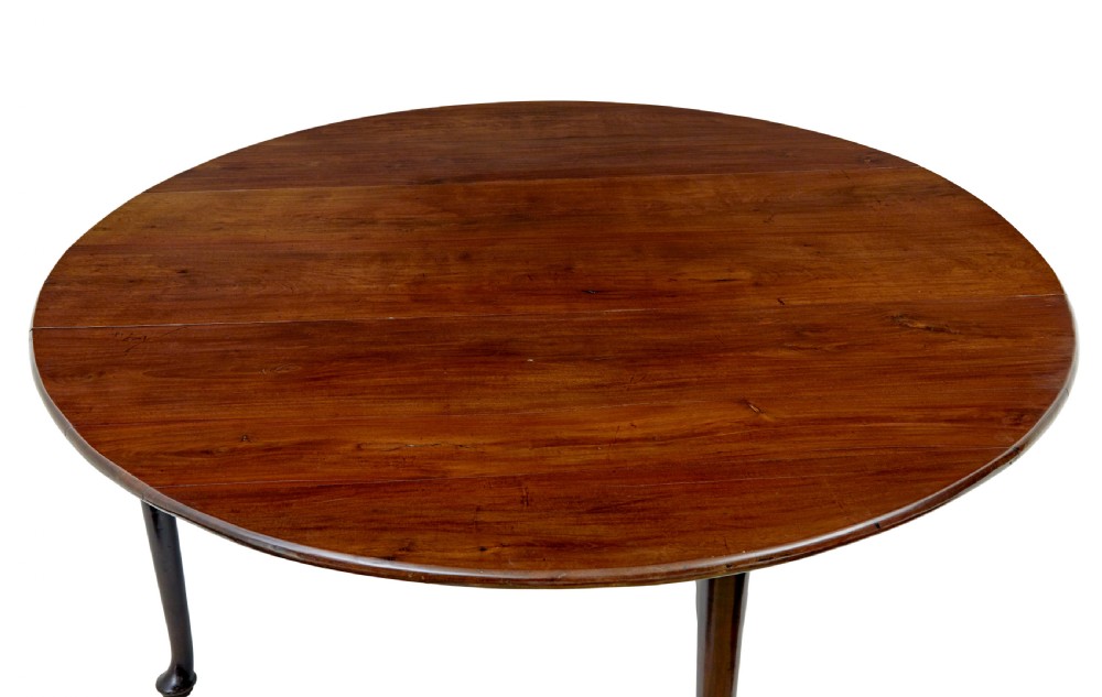 An early nineteenth-century Georgian dark mahogany drop-leaf dining table shown with both flaps lowered and tapered legs visible. View VI