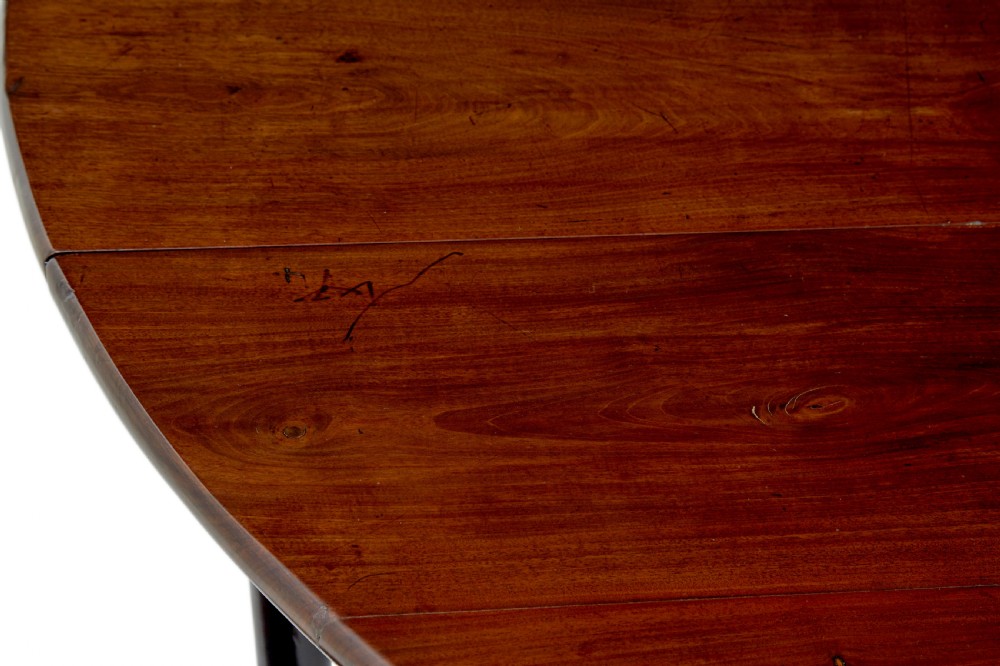 An early nineteenth-century Georgian dark mahogany drop-leaf dining table shown with both flaps lowered and tapered legs visible. View VII