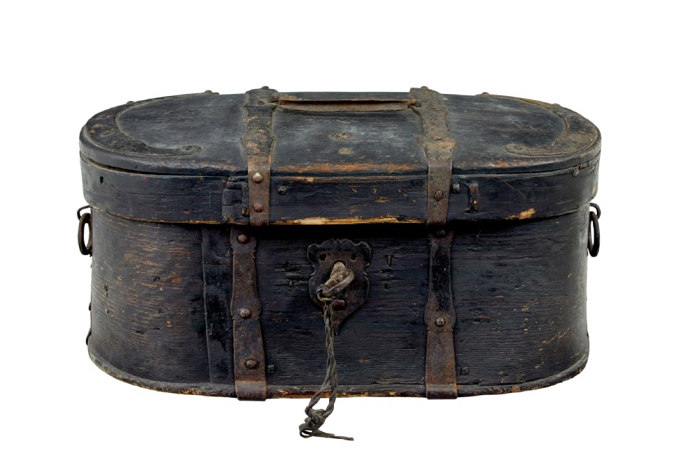 An oval 19th-century Swedish black painted wooden box featuring hand-forged iron straps, side carrying rings, and a key inserted into the central escutcheon.