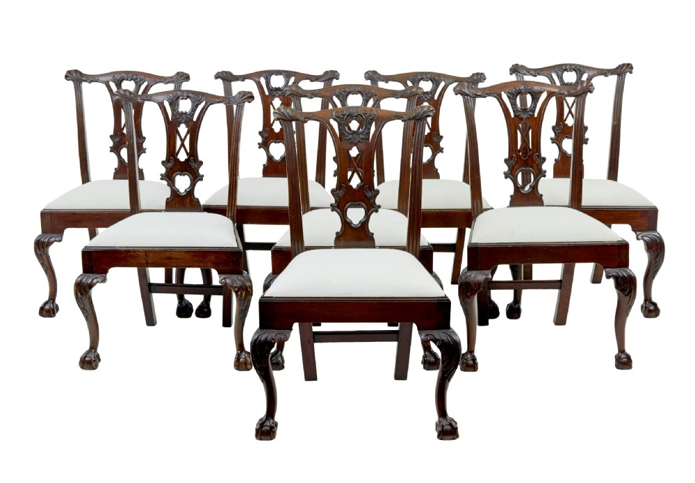A set of mahogany Chippendale style dining chairs featuring carved back splats, cabriole legs ending in ball and claw feet, and light-coloured upholstered drop-in seats.