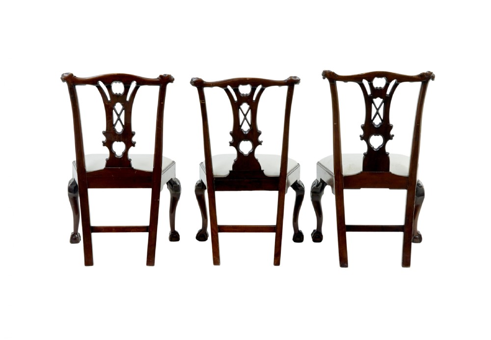 A set of mahogany Chippendale style dining chairs featuring carved back splats, cabriole legs ending in ball and claw feet, and light-coloured upholstered drop-in seats. View III