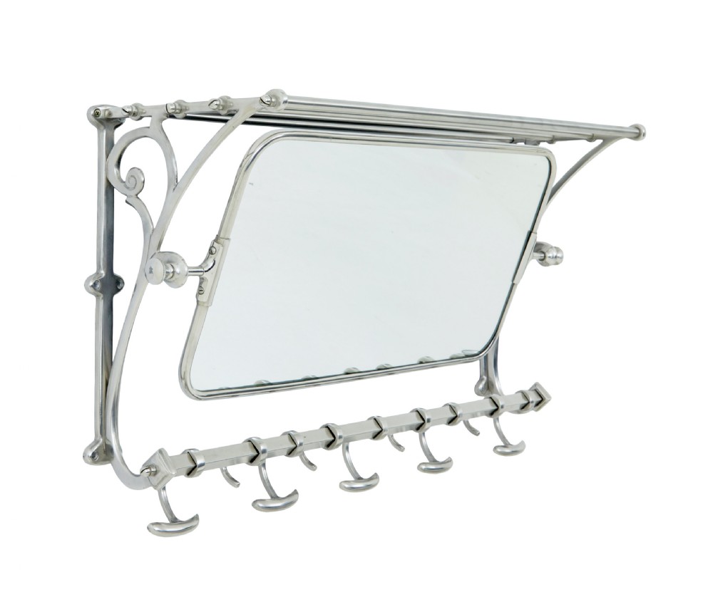 An early 20th-century chromed metal wall rack featuring a central tilting rectangular mirror, a top tubular shelf, and five lower double coat hooks. View II