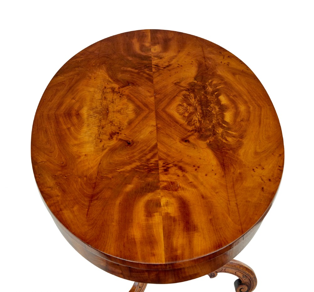 A 19th-century oval wood centre table featuring a figured veneer top, a turned central stem with acanthus leaf carving, and three scroll tripod legs. View IV