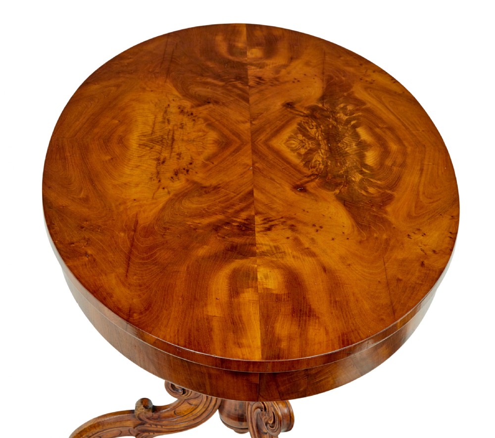 A 19th-century oval wood centre table featuring a figured veneer top, a turned central stem with acanthus leaf carving, and three scroll tripod legs. View V