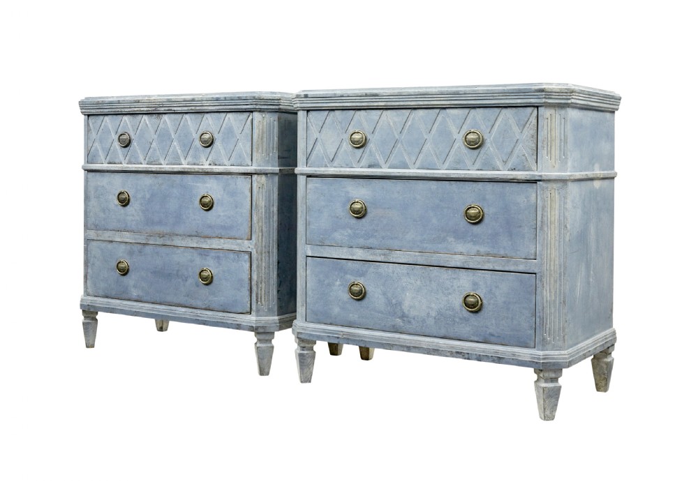 A pair of 19th-century Swedish Gustavian influenced three-drawer chests of drawers with a muted grey-blue painted finish and brass ring handles.