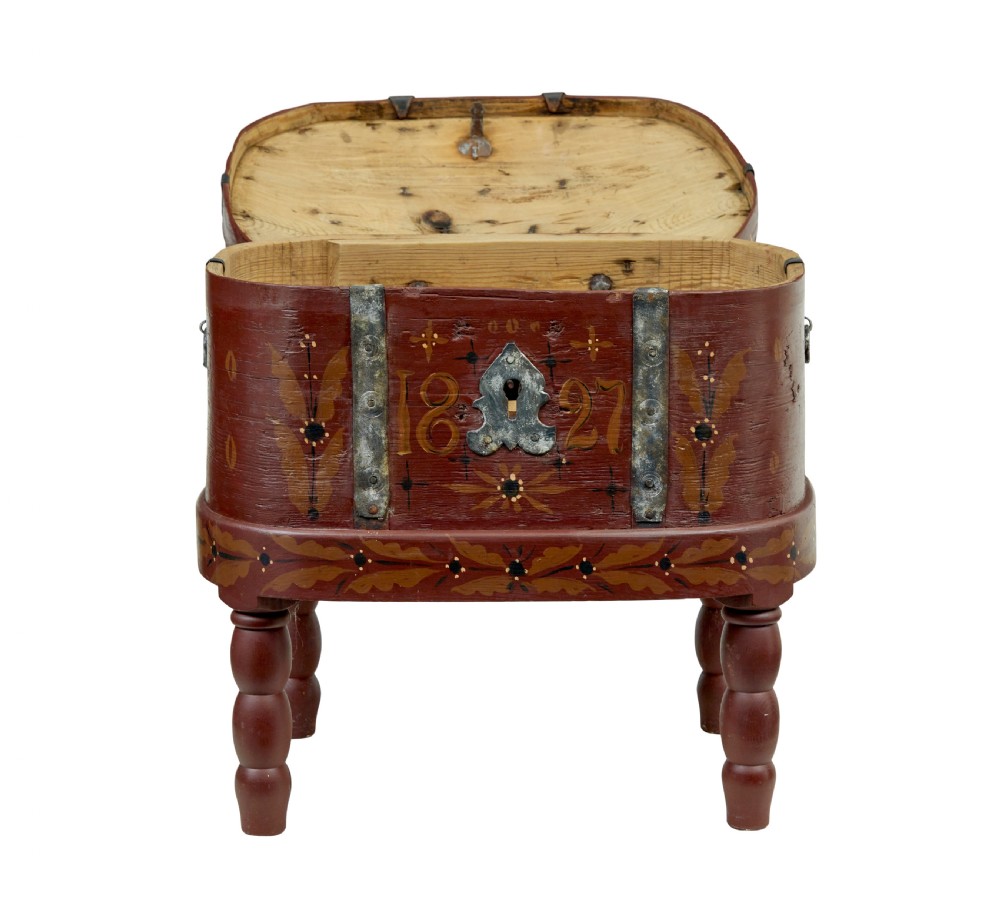 A Swedish folk art painted wooden coffer on turned legs, decorated with red paint, floral motifs, iron straps, and a painted 1827 date. View III