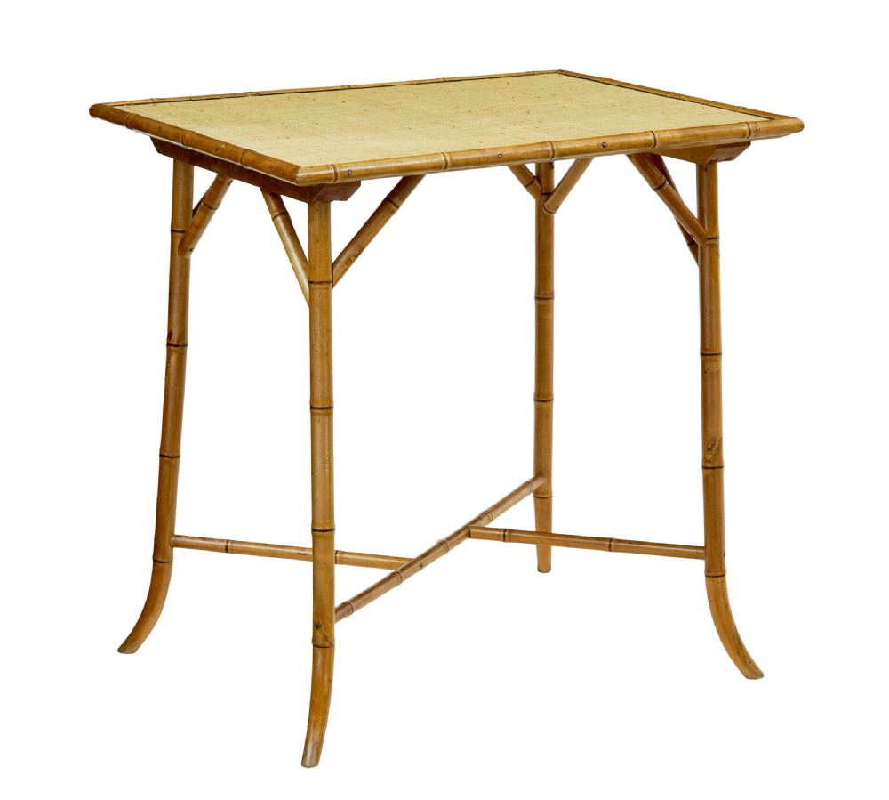 An early 20th-century bamboo side table featuring a rectangular woven hessian top panel, diagonal support struts, and outward curving lower legs.