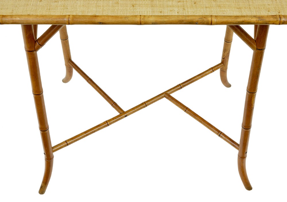 An early 20th-century bamboo side table featuring a rectangular woven hessian top panel, diagonal support struts, and outward curving lower legs. View V