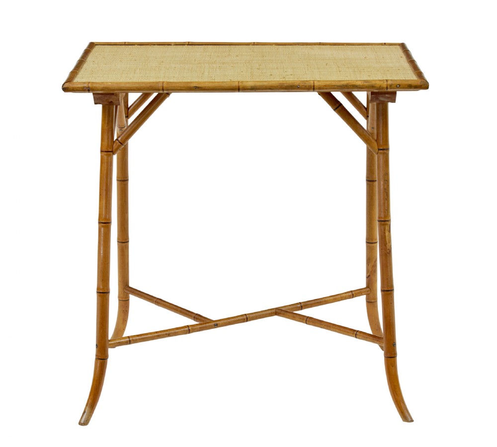 An early 20th-century bamboo side table featuring a rectangular woven hessian top panel, diagonal support struts, and outward curving lower legs. View VI