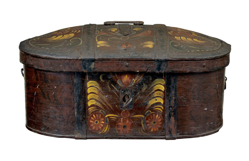 An oval dark brown 19th-century wooden box featuring hand-painted yellow and red floral folk motifs with iron bands and a latch.