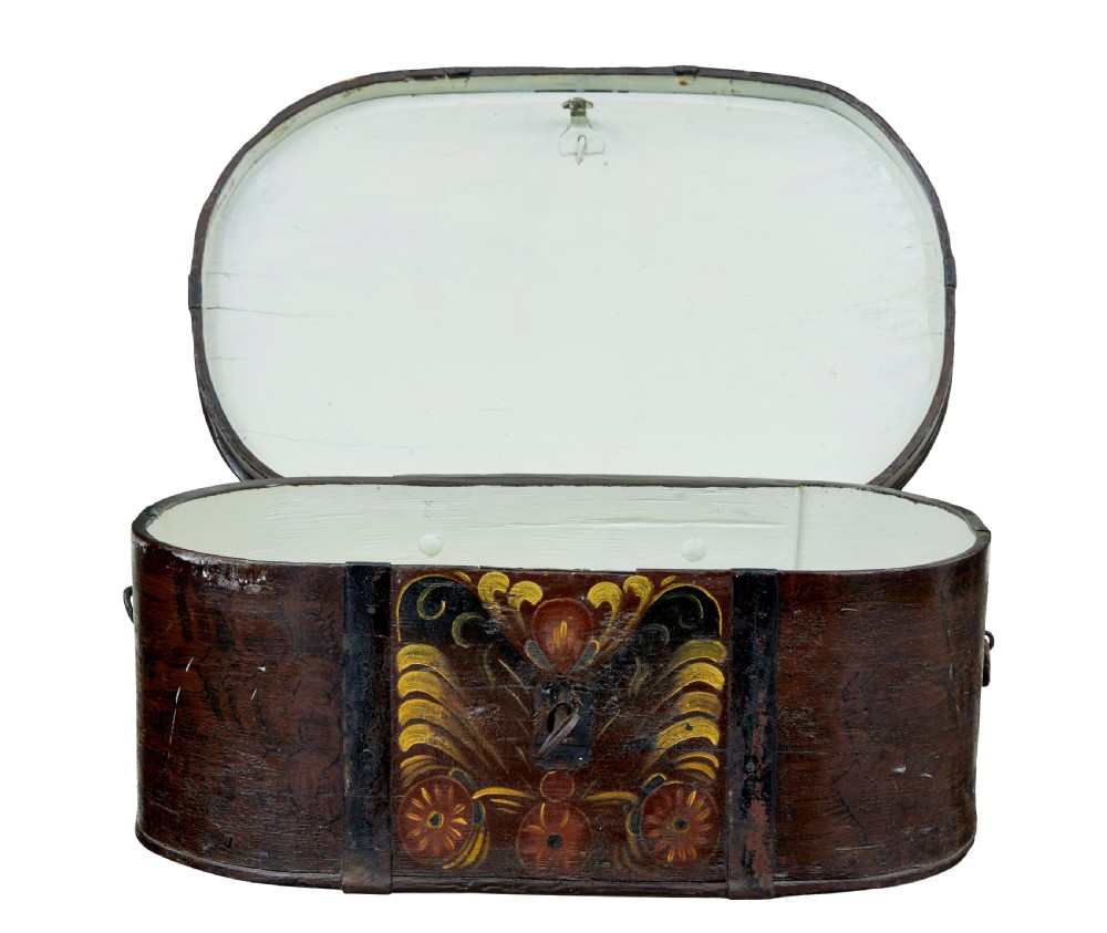 An oval dark brown 19th-century wooden box featuring hand-painted yellow and red floral folk motifs with iron bands and a latch. View II