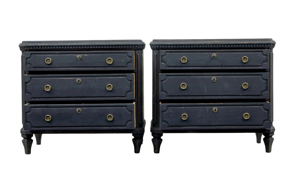 A matching pair of 19th-century Swedish black painted pine commodes, each featuring three drawers with moulded geometric panel fronts and brass drop handles. View II
