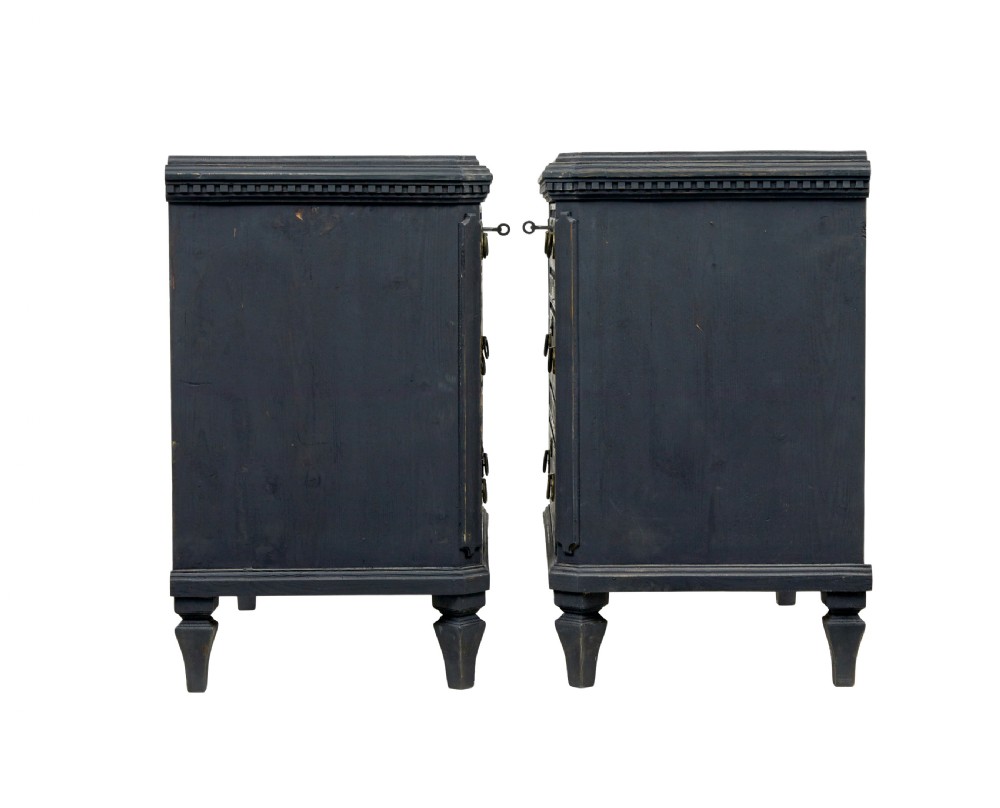 A matching pair of 19th-century Swedish black painted pine commodes, each featuring three drawers with moulded geometric panel fronts and brass drop handles. View V