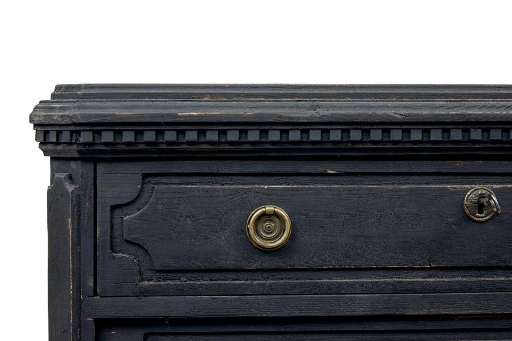 A matching pair of 19th-century Swedish black painted pine commodes, each featuring three drawers with moulded geometric panel fronts and brass drop handles. View VI