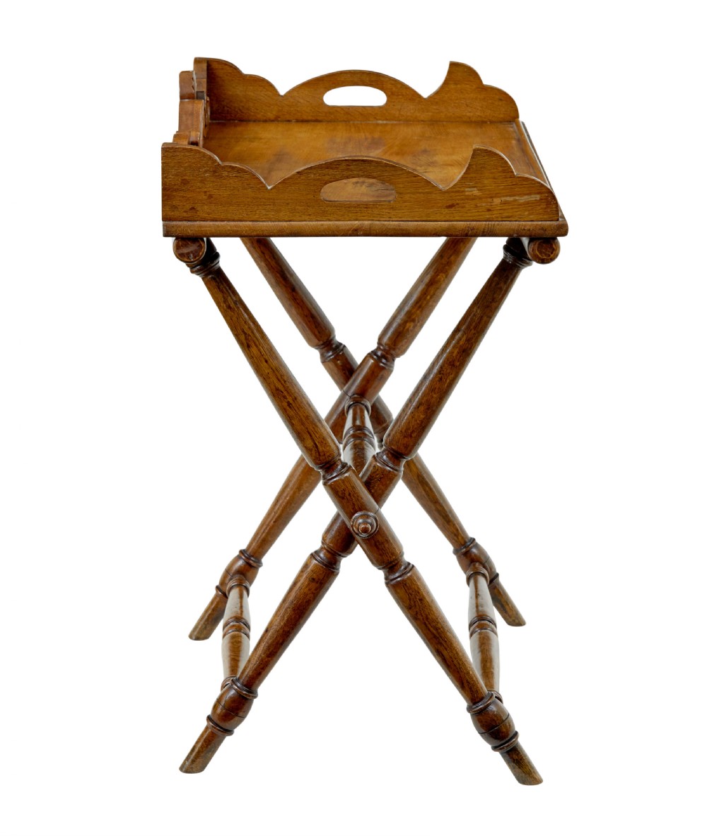 A 19th-century solid oak butler tray with carved gallery handles resting on a folding x-frame stand with turned spindles. View IV