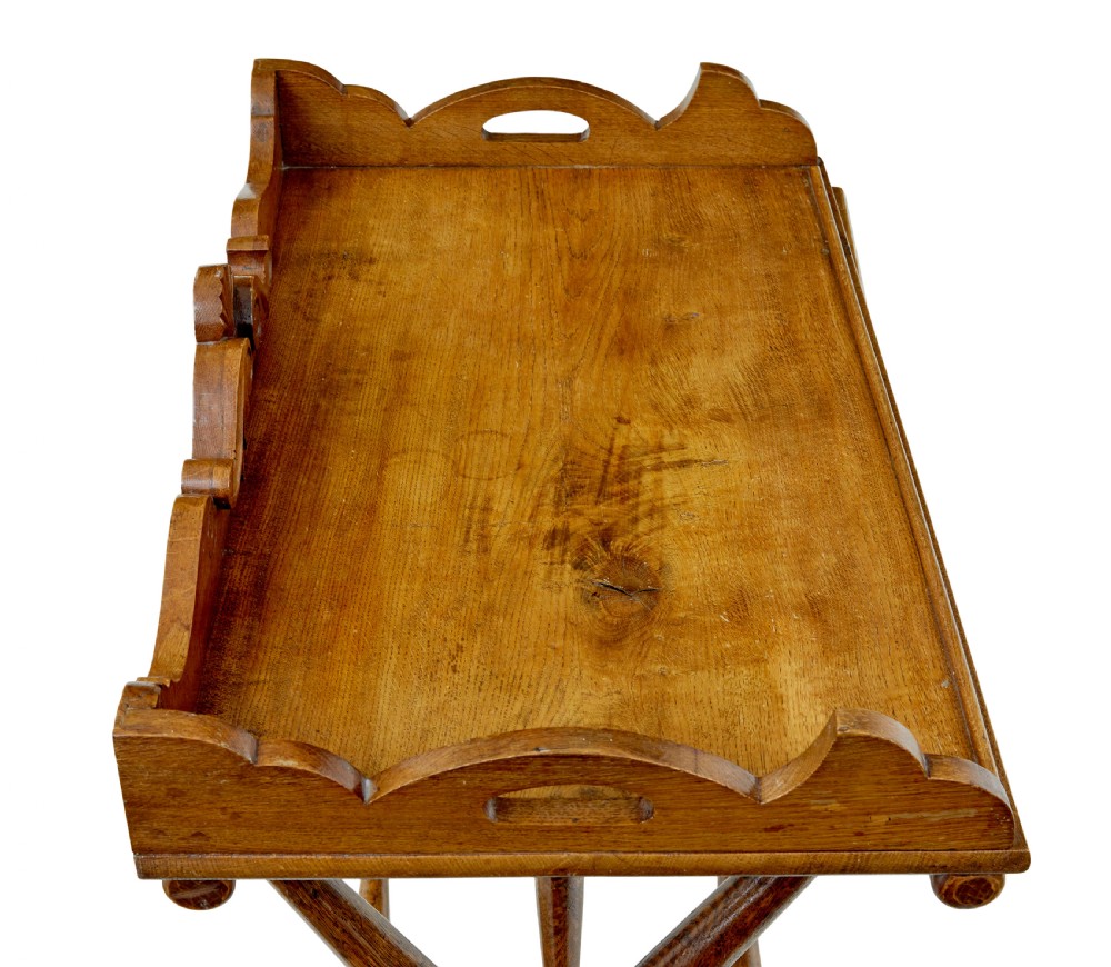 A 19th-century solid oak butler tray with carved gallery handles resting on a folding x-frame stand with turned spindles. View VI