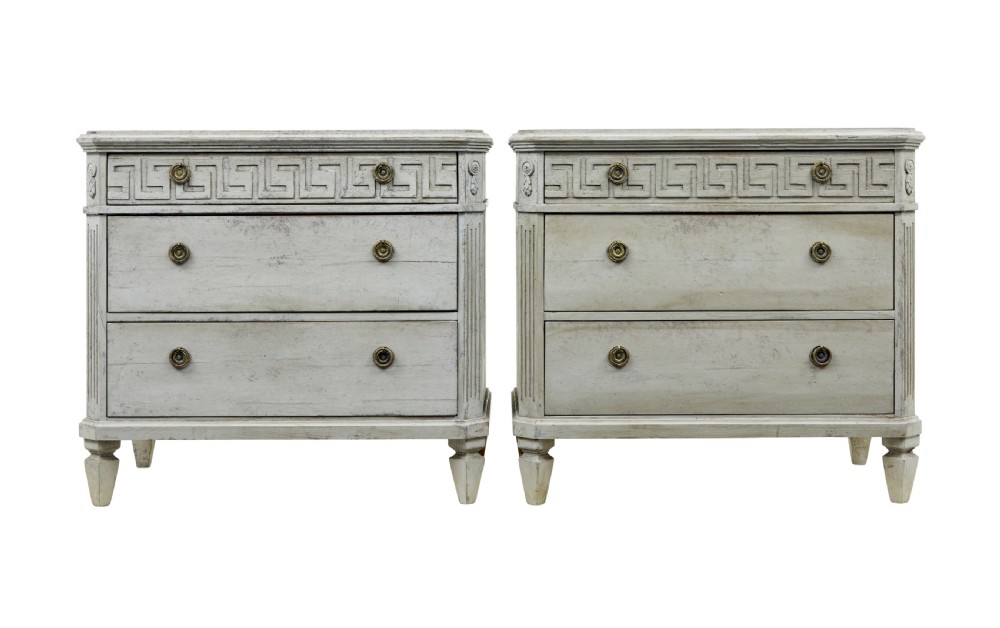 A pair of nineteenth-century Swedish Gustavian grey painted chests of drawers featuring Greek key frieze carving, fluted corners, and brass ring pulls.
