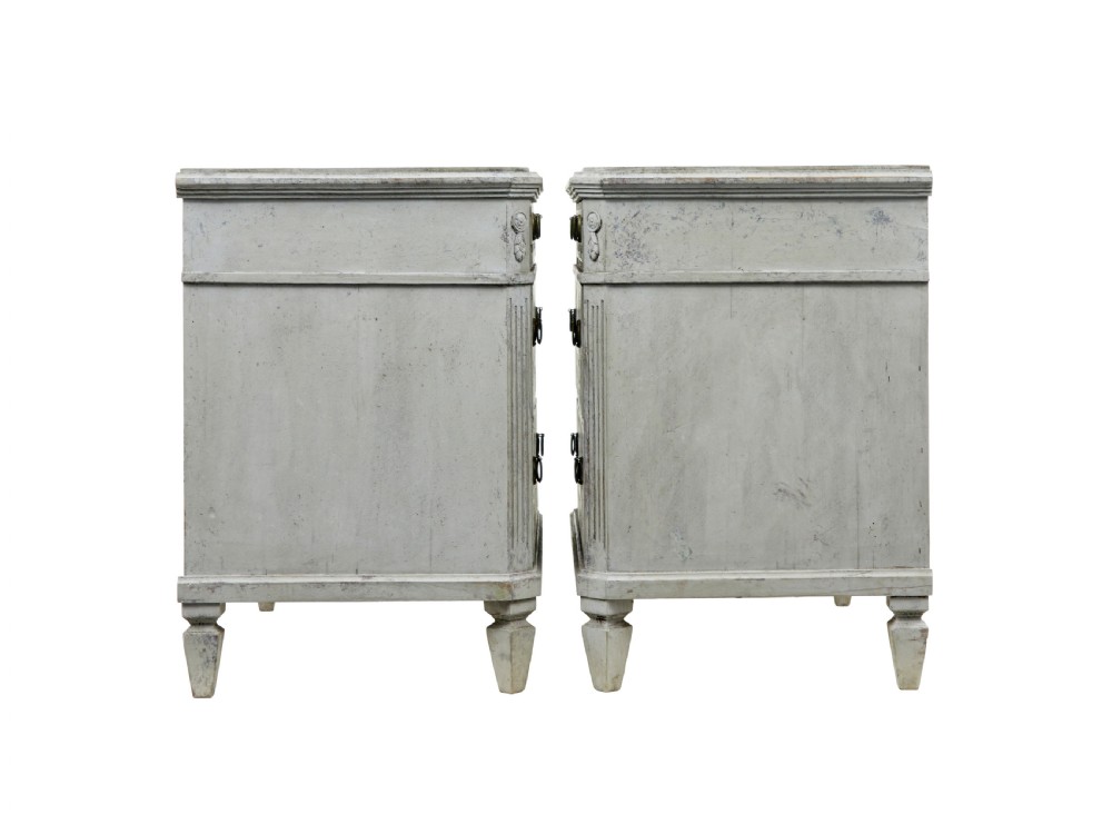 A pair of nineteenth-century Swedish Gustavian grey painted chests of drawers featuring Greek key frieze carving, fluted corners, and brass ring pulls. View V