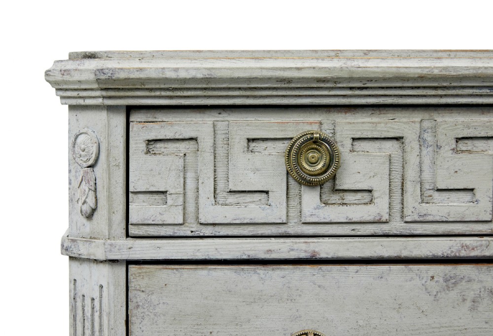 A pair of nineteenth-century Swedish Gustavian grey painted chests of drawers featuring Greek key frieze carving, fluted corners, and brass ring pulls. View VI