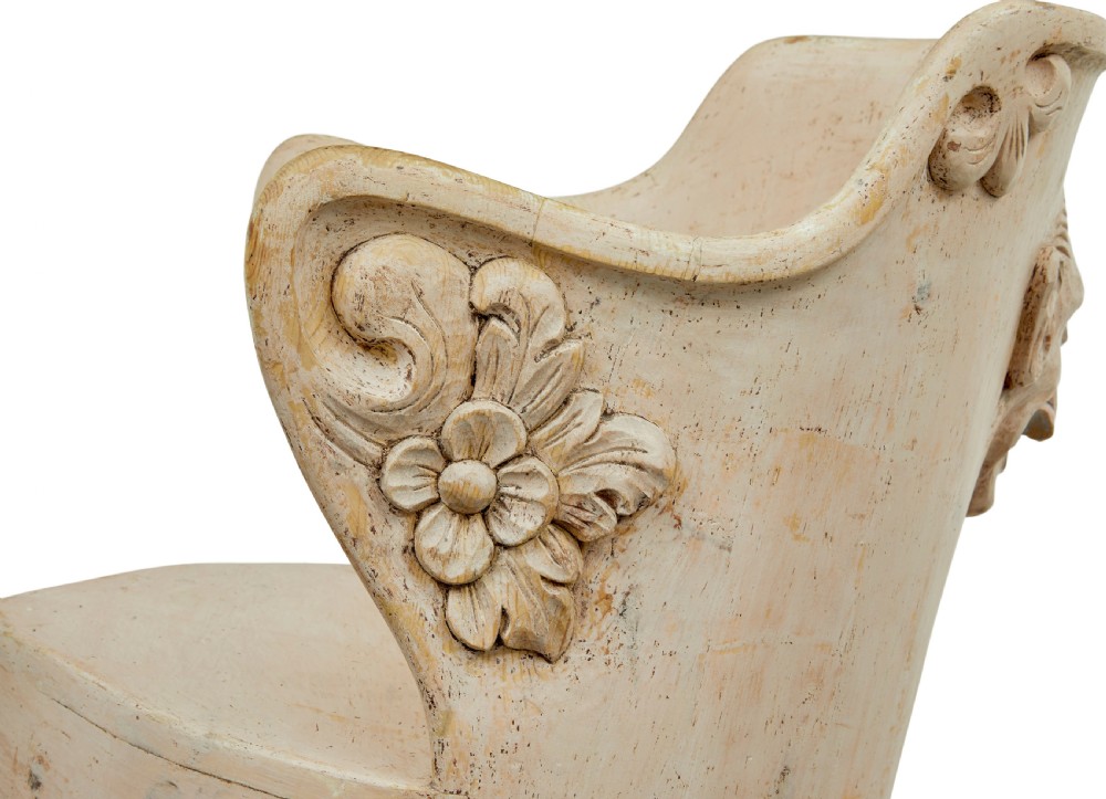 An antique cream-painted dugout armchair carved from a single timber section with relief floral scrollwork and hand-painted figures on the backrest. View IV
