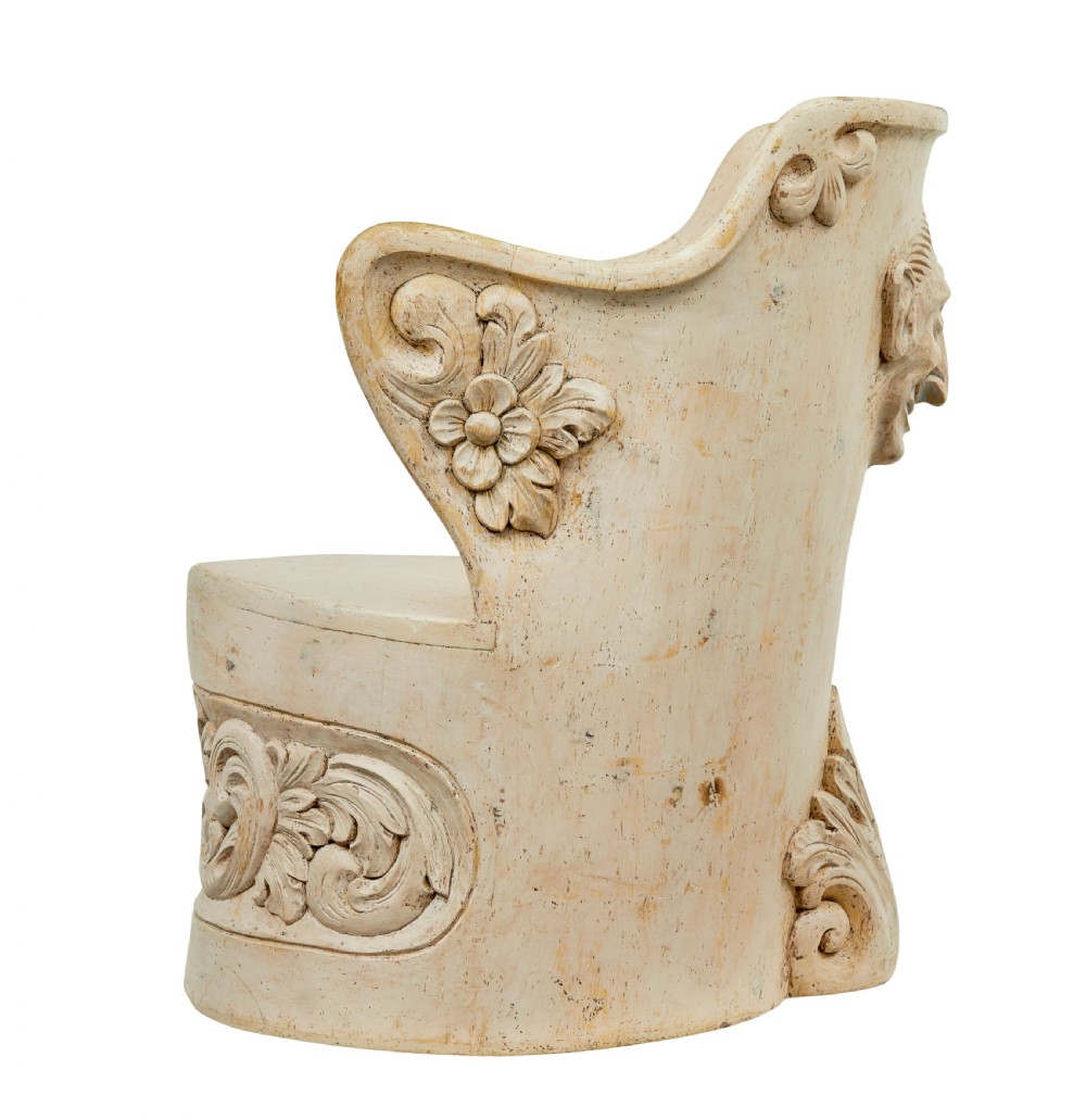 An antique cream-painted dugout armchair carved from a single timber section with relief floral scrollwork and hand-painted figures on the backrest. View X