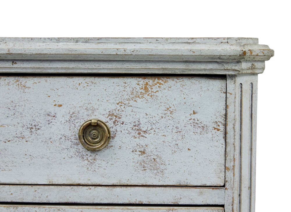 A pair of 19th-century Gustavian style painted chests of drawers with three drawers each, brass pulls, fluted side columns, and distressed pale grey paint. View VI