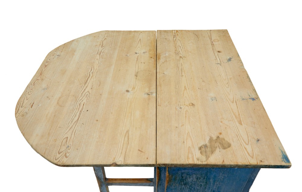 A 19th-century Swedish pine drop-leaf table featuring a raw timber top and a distressed blue painted base with a hinged leaf mechanism. View VI