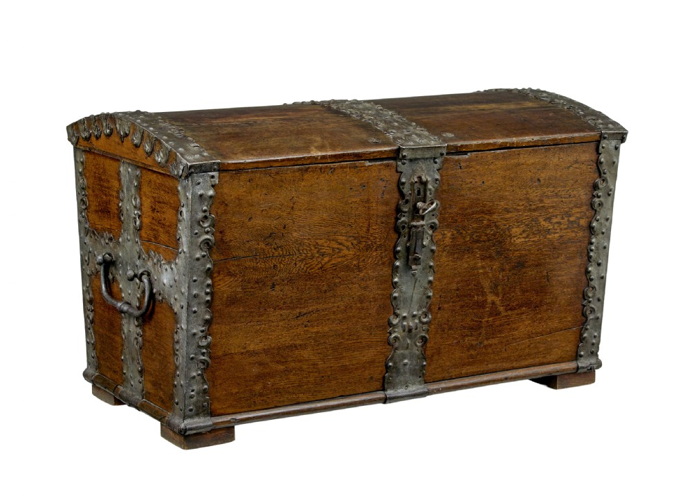 A mid-19th-century dome top oak chest featuring heavy iron strapwork mounts, side handles, and a central escutcheon.