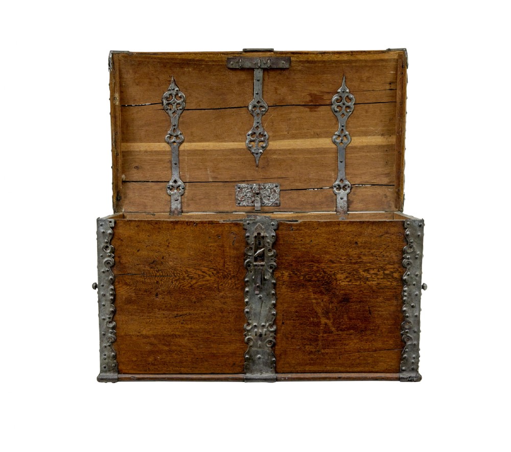 A mid-19th-century dome top oak chest featuring heavy iron strapwork mounts, side handles, and a central escutcheon. View III