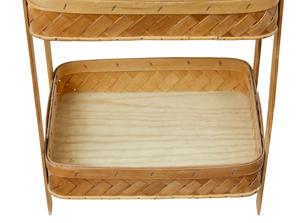 An early twentieth-century two-tier stand constructed from light-coloured woven pine splints with a bentwood arch handle and straight timber legs. View III