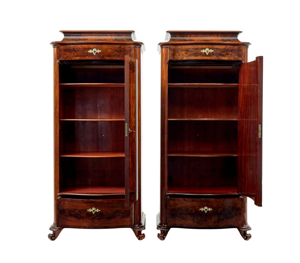 A pair of 19th-century Scandinavian tall mahogany cupboards featuring serpentine fronts, flame veneer panels, and ornate brass keyhole escutcheons. View III